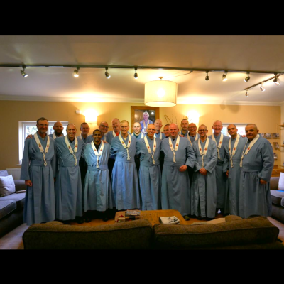 Ordained men in blue robes and kesas