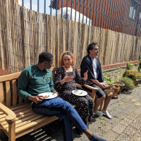 people of colour sat eating and talking